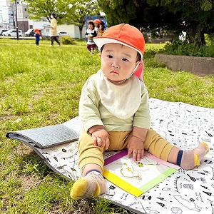 公園で敷物に座る子どもたち