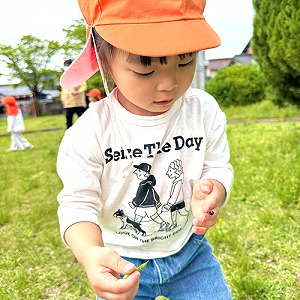 手にとまったテントウムシをみつめる子ども