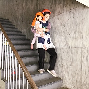 子どもを抱きかかえて屋外に避難する保育士