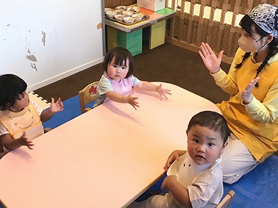 給食の前に歌をうたう子どもたちと保育士