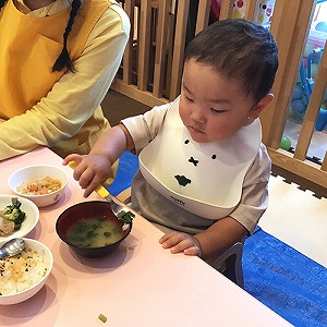 フォークをじょうずに使ってみそ汁を食べる子ども