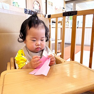 真剣な表情で折り紙をちぎる子ども
