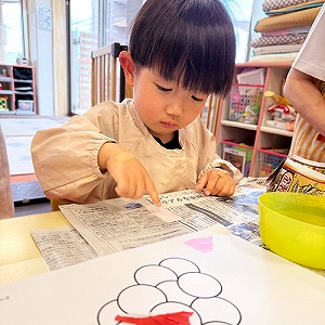 折り紙をのりで貼る子ども