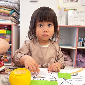 折り紙をのりで貼る子ども