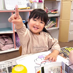 指についたんのりを見せる子ども