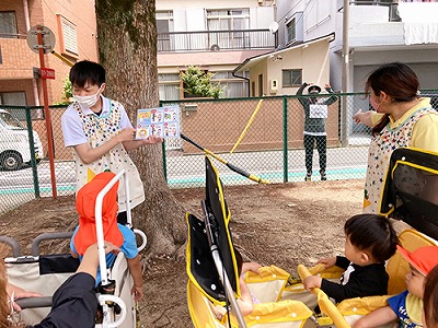 子どもたちにいかのおすしの約束をする保育士。背後には不審者?
