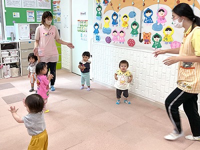 朝の会で音楽に合わせて踊る子どもたちと保育士