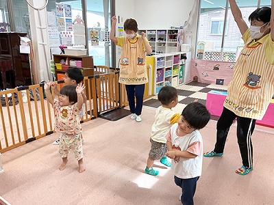 朝の会で音楽に合わせて踊る子どもたちと保育士