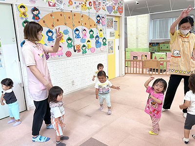 朝の会で音楽に合わせて踊る子どもたちと保育士