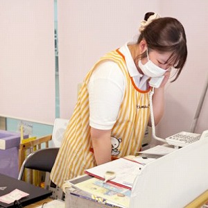 電話で話す保育士
