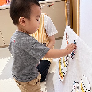 バースデーケーキのパネルに飾り付けをする子ども