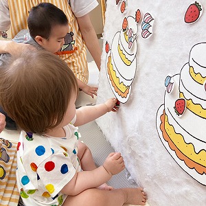 バースデーケーキのパネルに飾り付けをする子どもたち