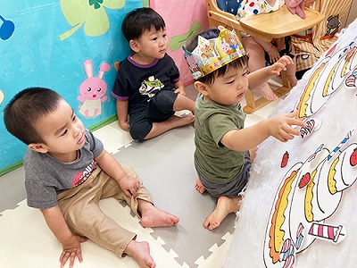 誕生日ケーキのパネルシアターを見つめる子どもたち