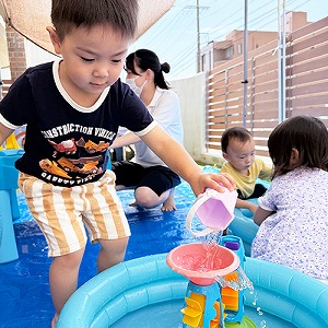 バケツで水を移す子ども