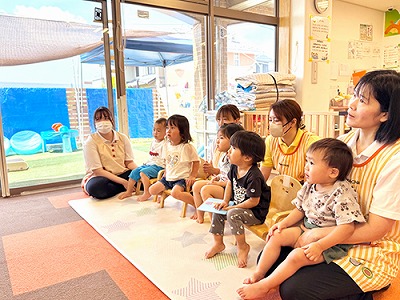 先生が披露するエプロンシアターを楽しむ子どもたち