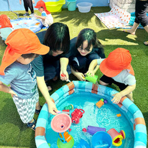 子どもたちと水遊びをする中学生たち