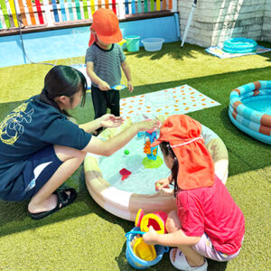 子どもたちと水遊びをする中学生