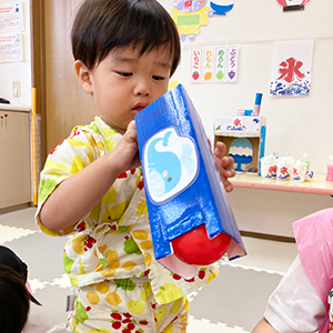 夏まつりの魚釣りに挑戦する子ども
