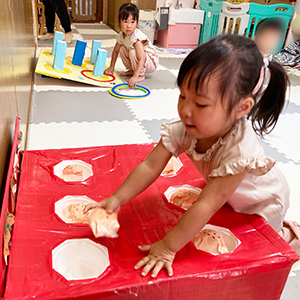 夏まつりでたこ焼き投げをする子ども