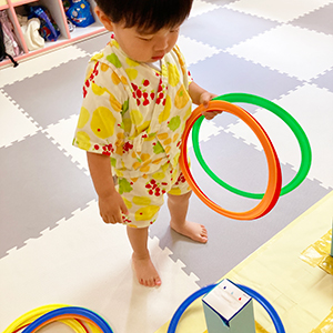 夏まつりの輪投げをする子ども