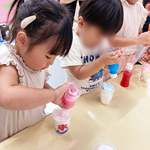 夏まつりでかき氷作りに夢中な子ども