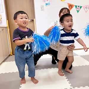 ボンボンを持って準備体操をする子どもたちの様子