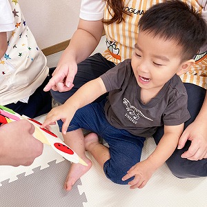 エプロンシアターの最後に出てきた大きなケーキを指さす子ども