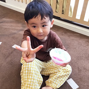 かき氷を持ってピースサインをする子ども