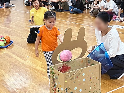 動物の口にフルーツをイメージした玉を入れる子ども