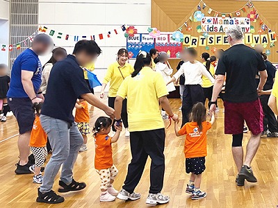 輪になってダンスをする親子たち