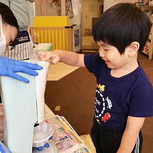 かき氷器のボタンを押す子ども