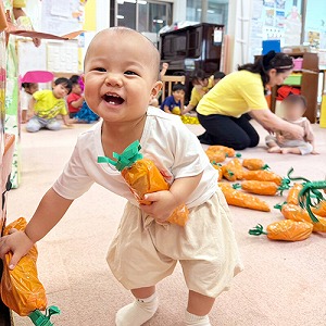 にんじんを抱きかかえて笑う子ども