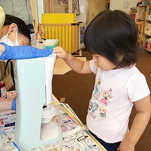 かき氷器のボタンを押す子ども