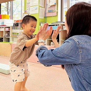 先生とハイタッチをする子ども