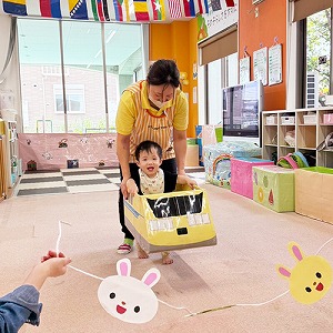 先生と一緒に新幹線になって歩く子ども