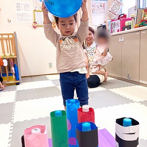 モンスターのピンにボールを投げる子ども