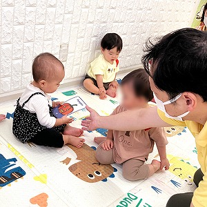 子どもが持つ英語カードを指さす先生