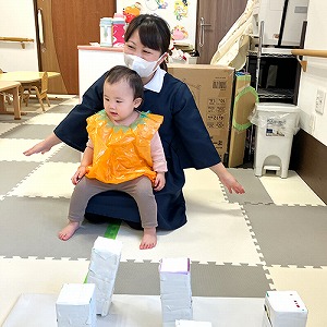 保育士の膝に乗る子ども